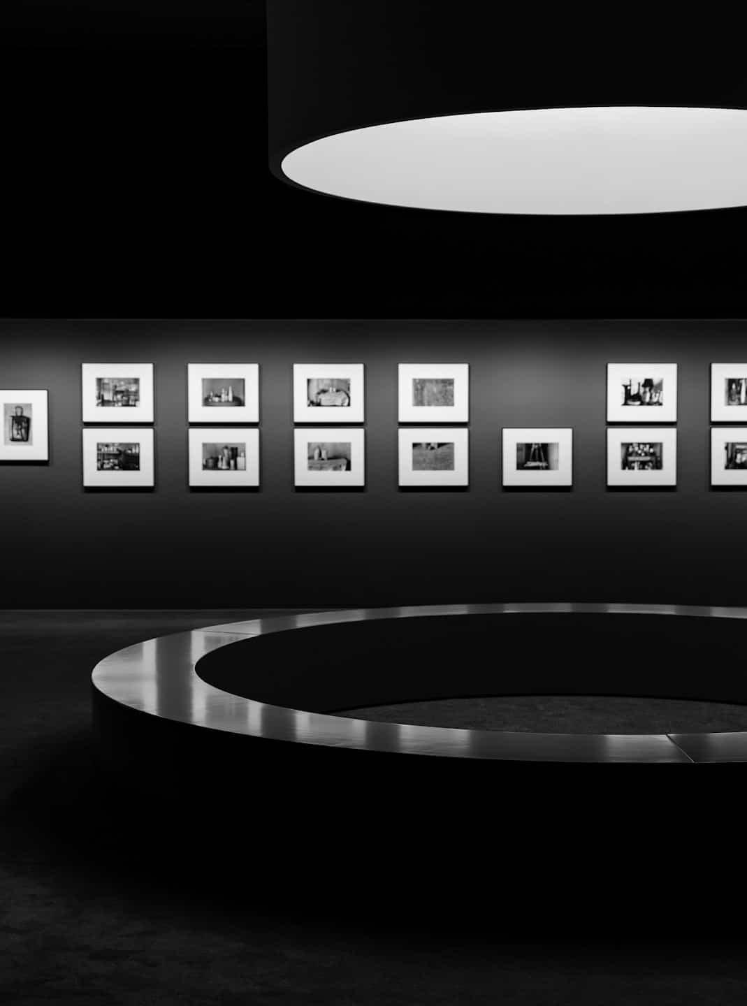 Fotografie in bianco e nero incorniciate esposte su una parete da galleria.