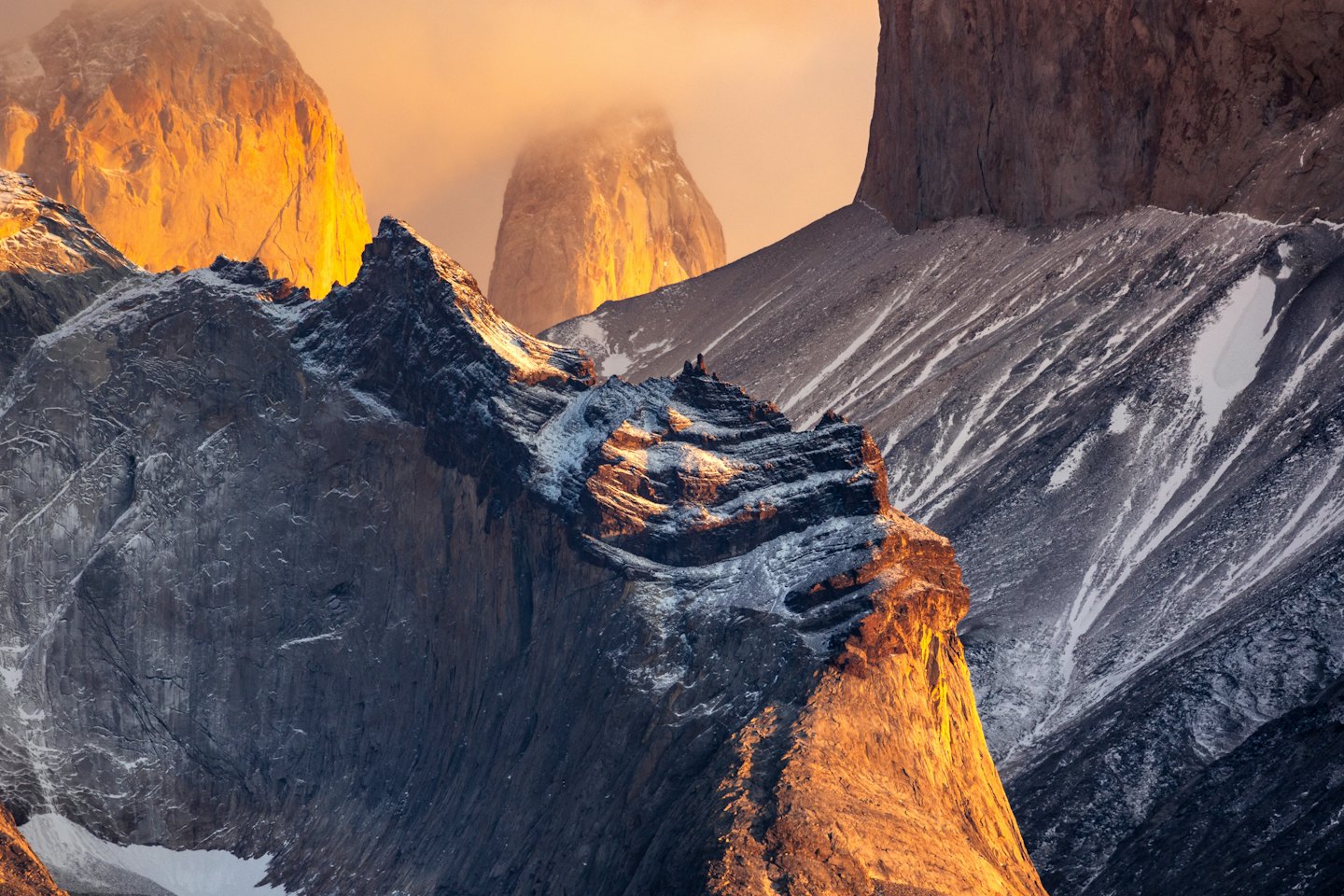 Luce dorata dell'alba sulle cime delle montagne con nuvole nebbiose.