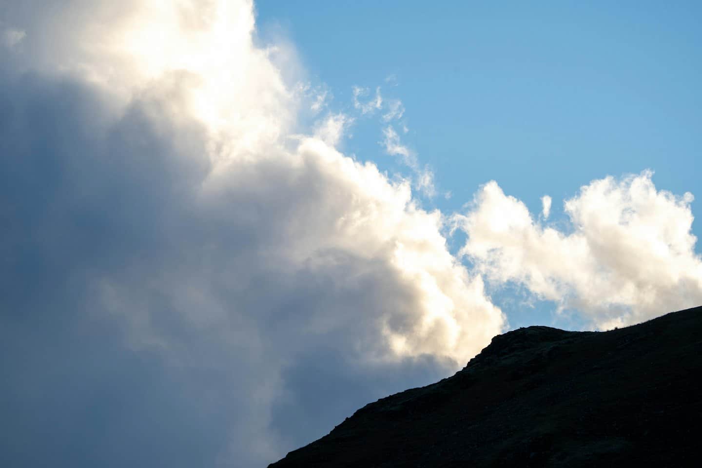 Colline scoscese stagliate contro un cielo nuvoloso.